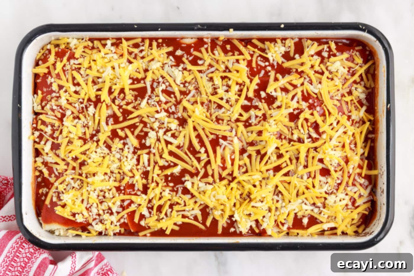 Cheesy Chicken Enchilada Bake 11 A thick layer of shredded cheese covering the entire top of the chicken enchilada casserole.