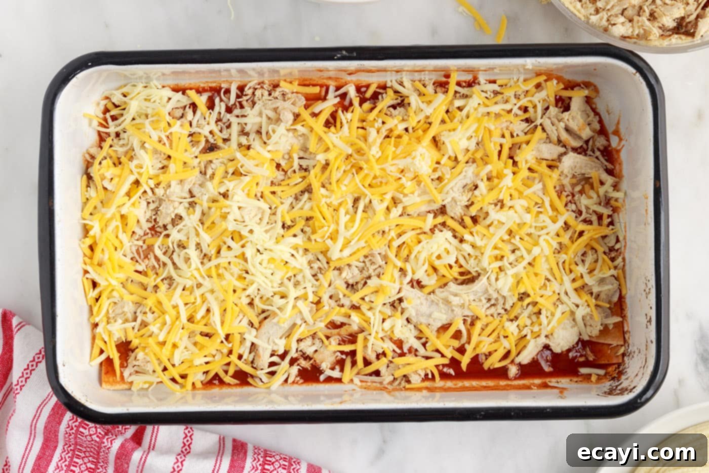 Cheesy Chicken Enchilada Bake 7 Generous layer of shredded cheese atop chicken and tortillas in the casserole.