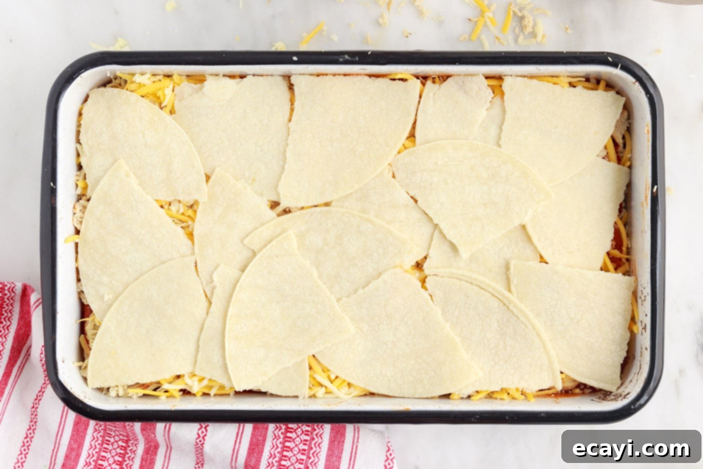 Cheesy Chicken Enchilada Bake 9 The final layer of torn corn tortillas covering the top of the casserole.