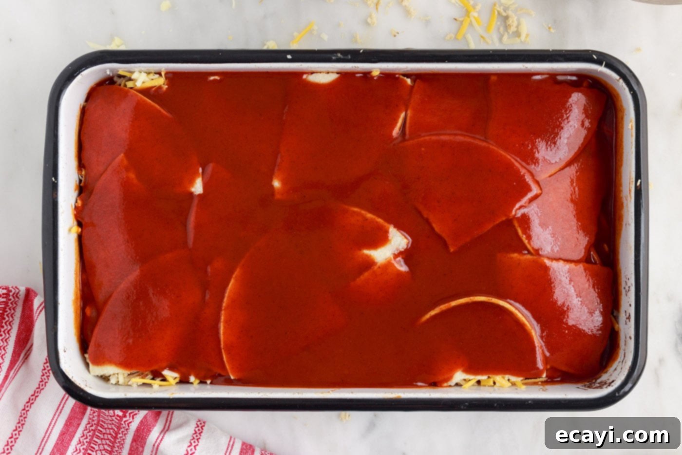Cheesy Chicken Enchilada Bake 10 Enchilada sauce poured over the top layer of tortillas in the casserole dish.