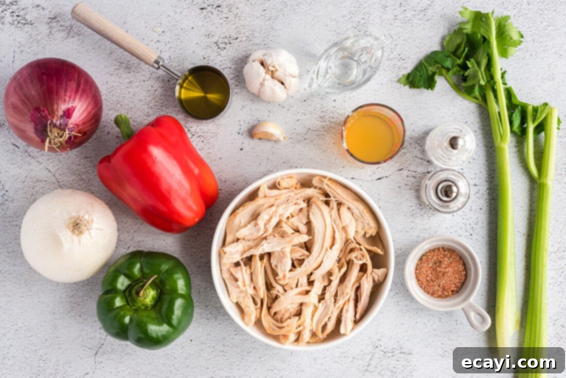 Bayou Chicken Salad 4 All fresh ingredients for making Cajun Chicken Salad are neatly arranged on a white backdrop, including cooked chicken, diced celery, red and white onions, red and green bell peppers, olive oil, minced garlic, white vinegar, chicken broth, and a vibrant pile of Cajun seasoning.