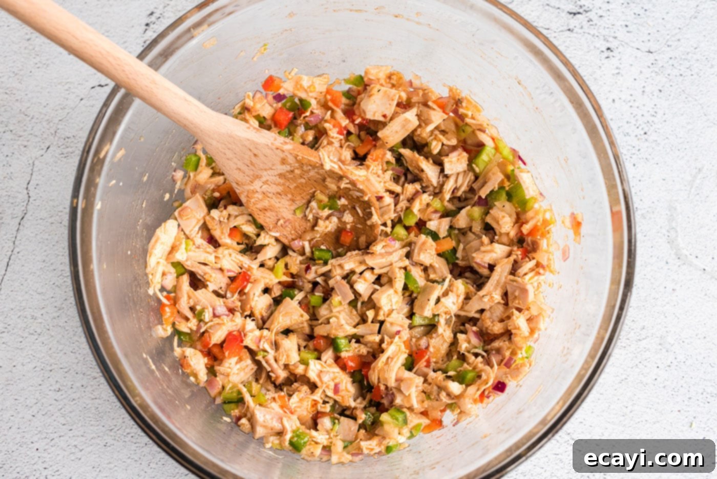 Bayou Chicken Salad 9 A large mixing bowl, securely covered with plastic wrap, containing the vibrant Cajun Chicken Salad, chilling in the refrigerator to allow flavors to meld.
