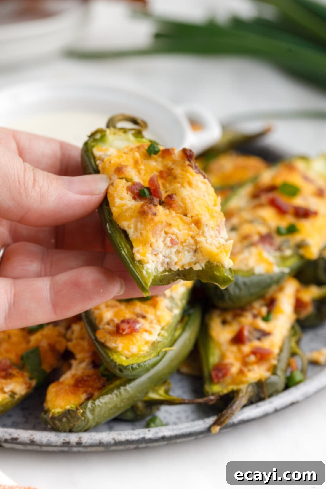 Golden Jalapeño Delights 5 A close-up of a baked Jalapeño Popper with a bite taken out, showing the creamy filling