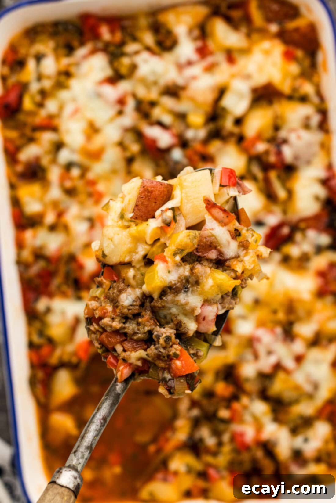 Hearty Sausage and Potato Bake 11 Spoonful of Sausage and Potato Casserole held above a casserole dish