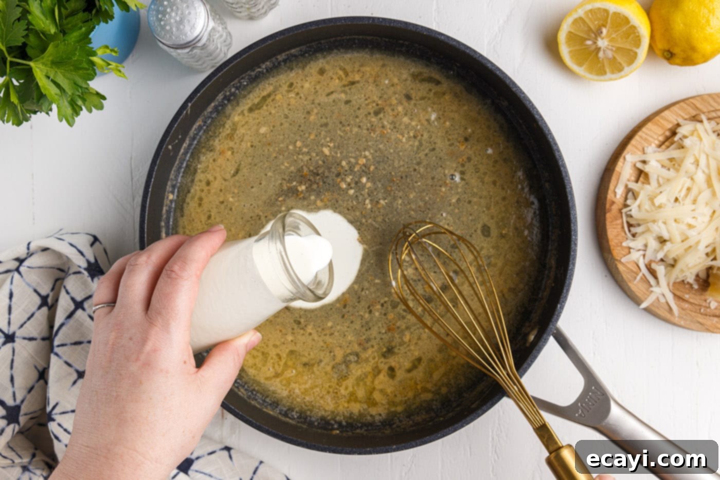 Creamy Garlic Shrimp Pasta 11 Adding Heavy Cream to Lemon Butter Sauce in a Skillet