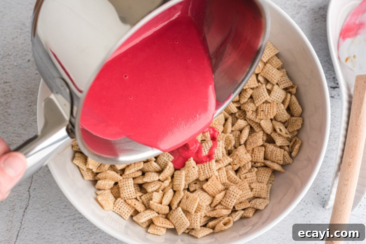 Sweetheart Muddy Buddies 7 pouring pink chocolate over chex cereal