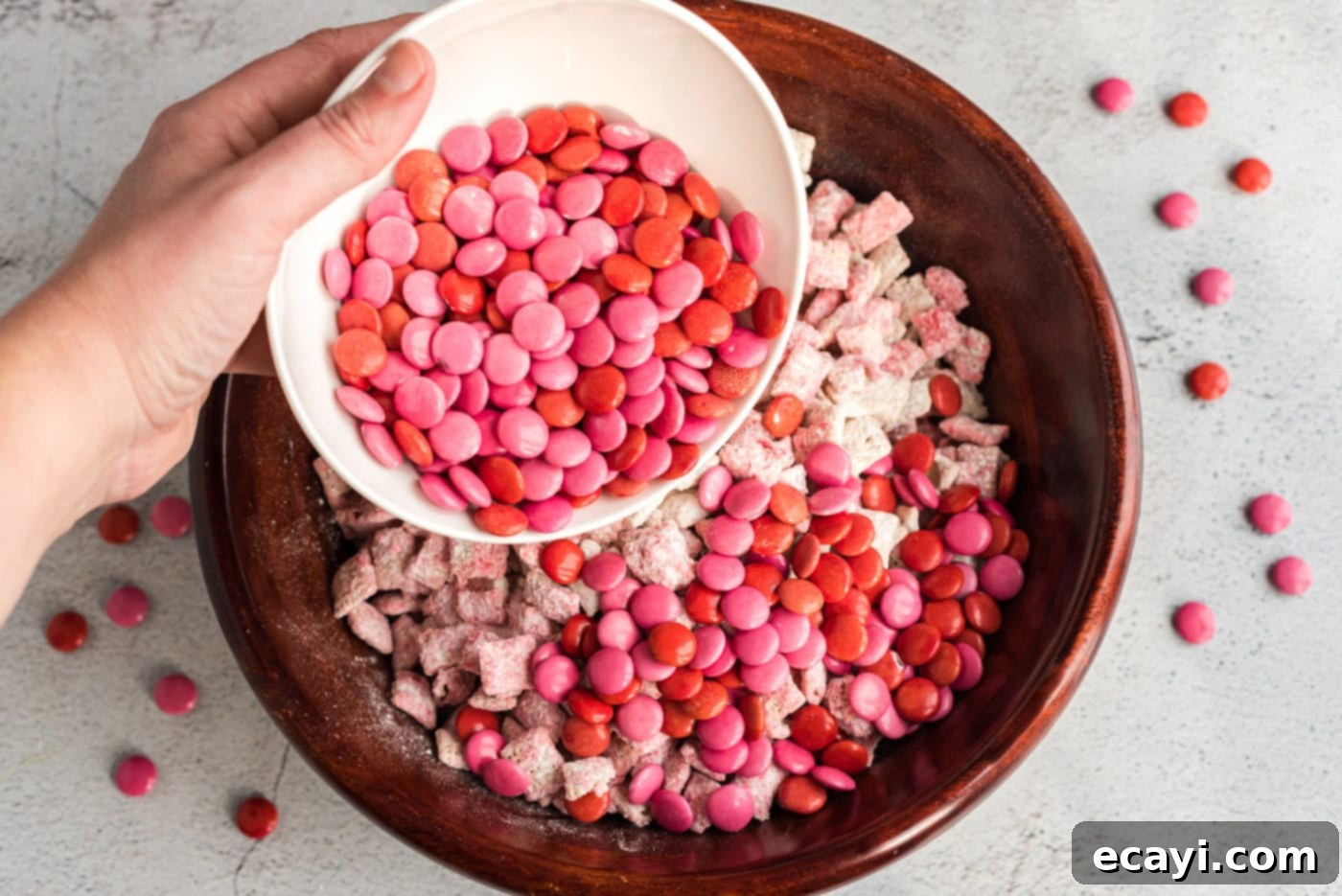 Sweetheart Muddy Buddies 10 pouring pink and red M&M's into puppy chow