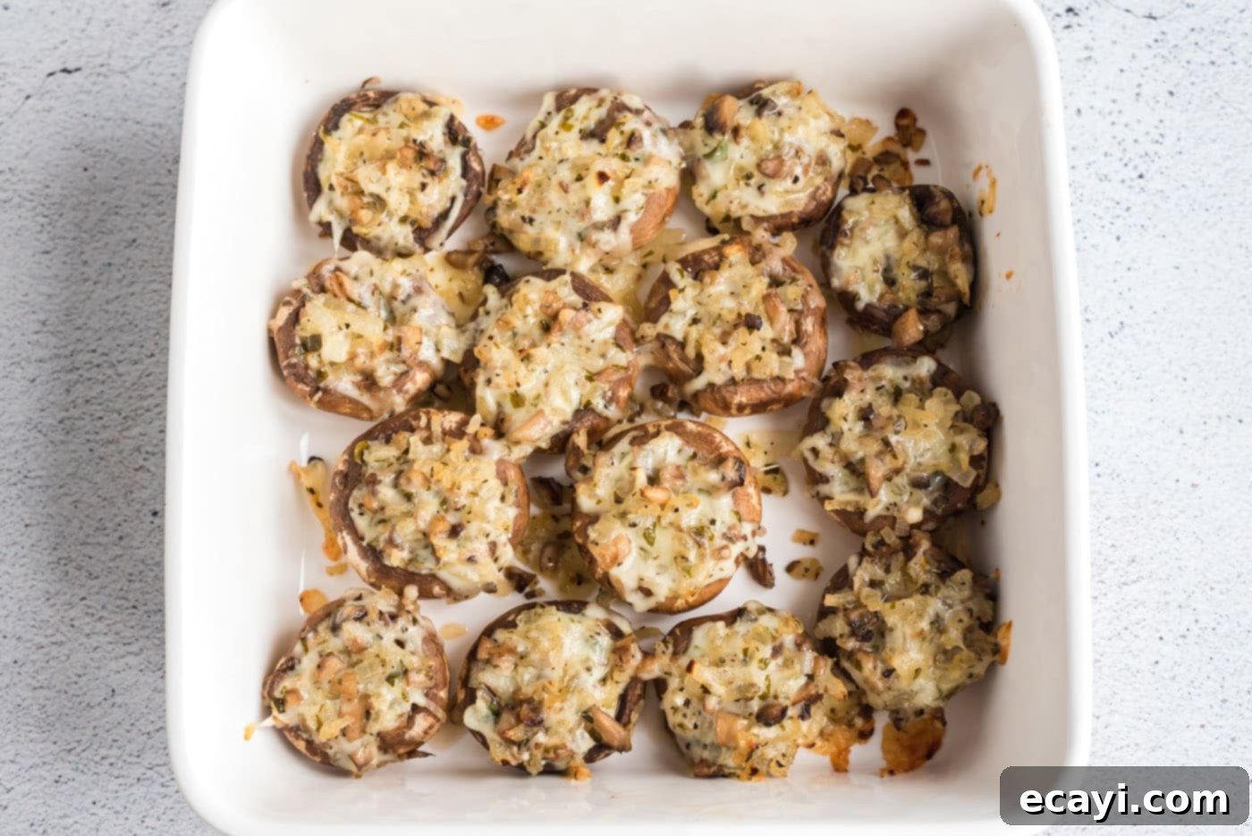 Gourmet Mushroom Poppers 8 A baking pan filled with golden-brown baked stuffed mushrooms, glistening with melted cheese.