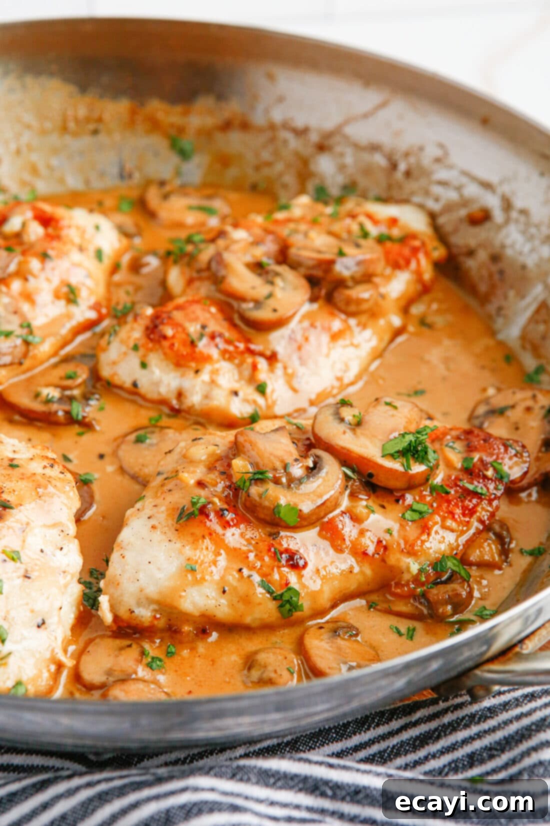 Savory Chicken Marsala 2 Chicken Marsala in a skillet, garnished with fresh parsley