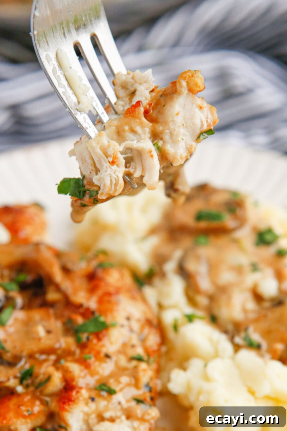 Savory Chicken Marsala 11 Close-up of a fork lifting a piece of Chicken Marsala with sauce and mushrooms