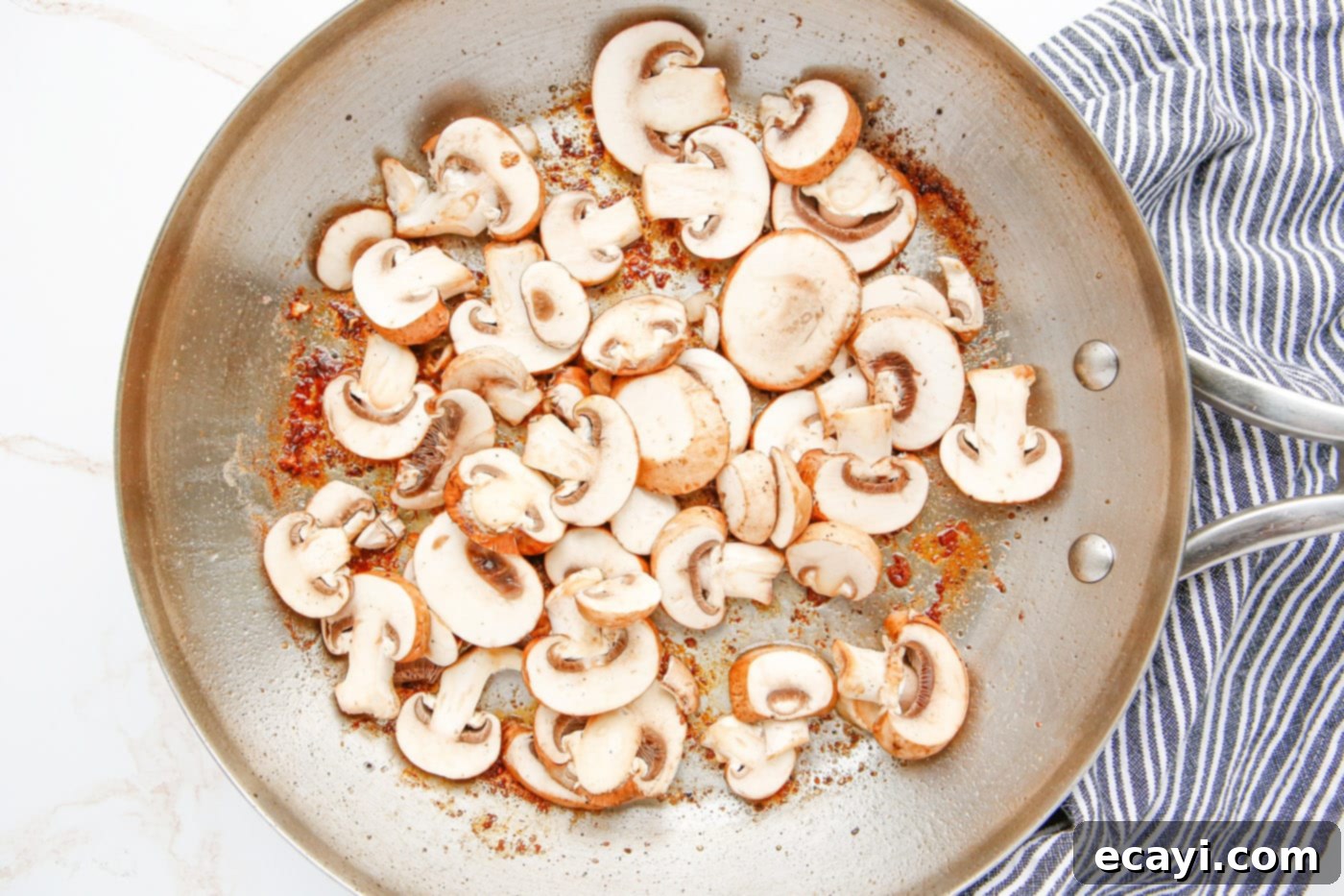 Savory Chicken Marsala 7 Sliced cremini mushrooms sautéing in butter and olive oil in a skillet