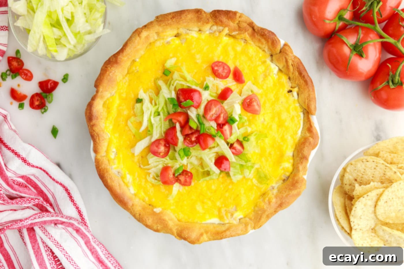 Ultimate Taco Casserole 13 diced tomatoes and lettuce on top of taco pie