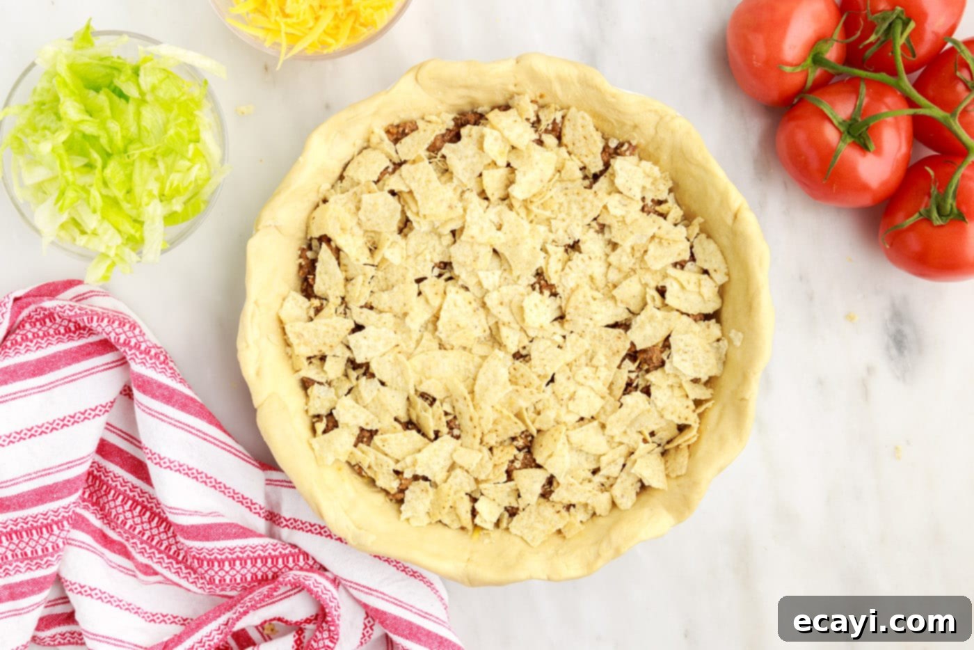 Ultimate Taco Casserole 9 crushed tortilla chips on top of ground beef pie