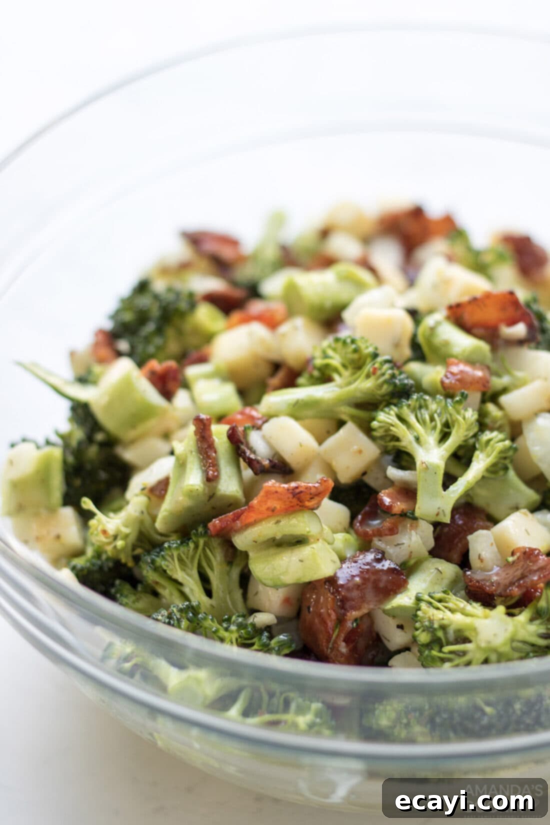 This broccoli salad is a fresh mixture of broccoli, bacon, cheese, and onion. Bring this staple dish to your next potluck or family gathering! #appetizers #potluck #saladrecipes #broccolisalad #broccoli #bacon #sidedishes #summerrecipes  bowl of broccoli salad