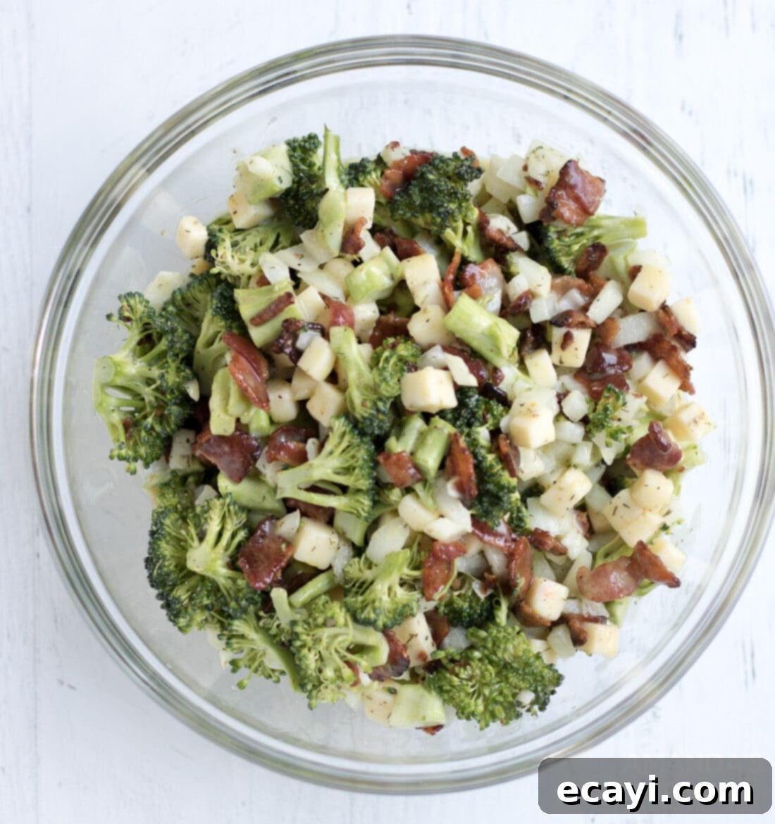 This broccoli salad is a fresh mixture of broccoli, bacon, cheese, and onion. Bring this staple dish to your next potluck or family gathering! broccoli salad in a bowl