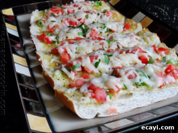 Mozzarella Provolone Bruschetta A close-up overhead shot of individual mozzarella provolone bruschetta pieces, showing the melted cheese and chopped tomatoes, inviting to eat.