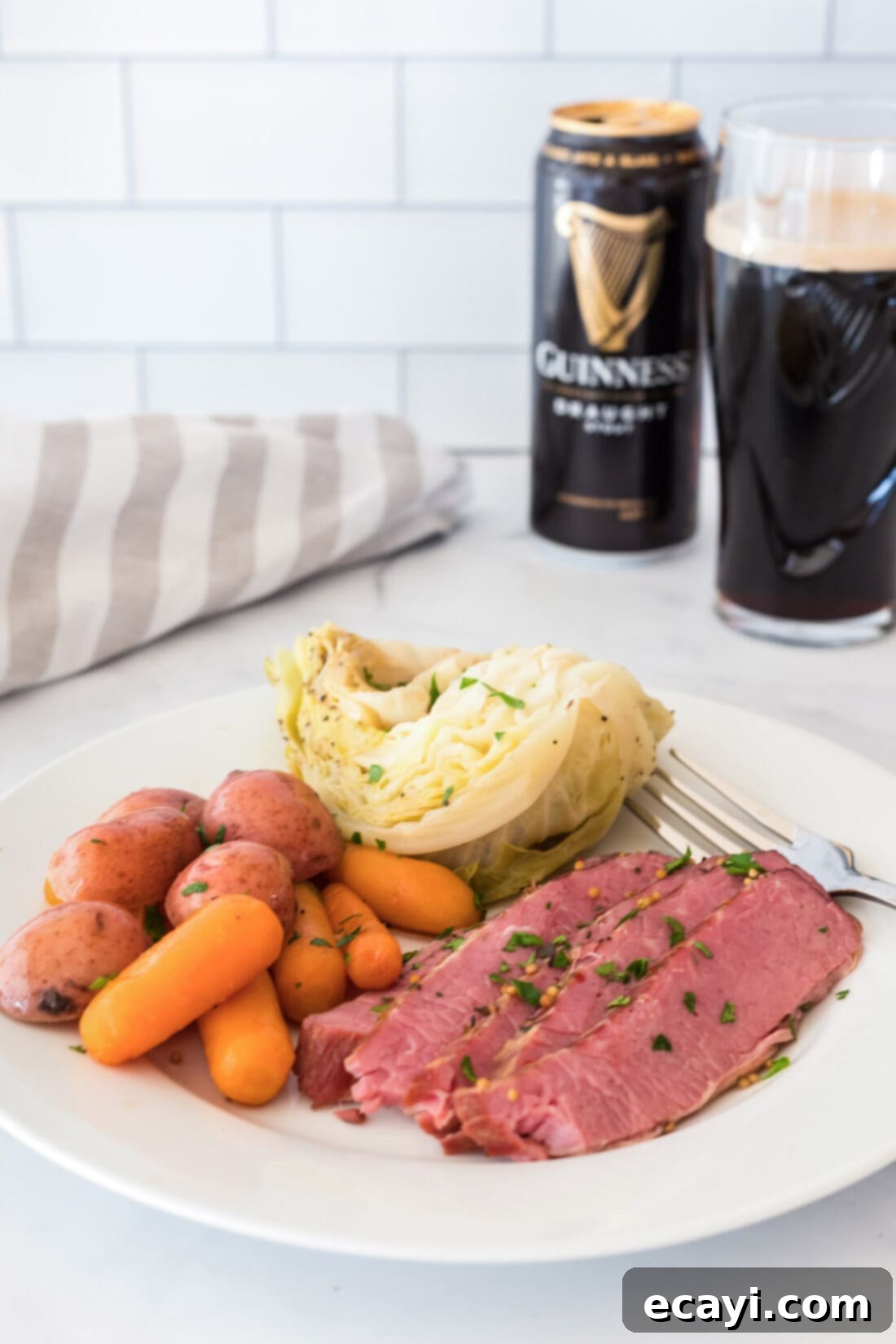 Tender Instant Pot Corned Beef 12 A serving of Instant Pot Corned Beef and vegetables on a white plate, ready to be enjoyed.