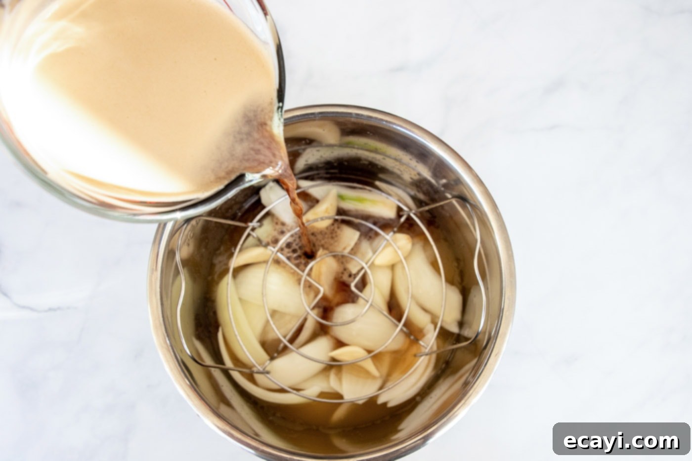 Tender Instant Pot Corned Beef 6 Guinness beer being poured into an Instant Pot over onion wedges and garlic cloves for corned beef.