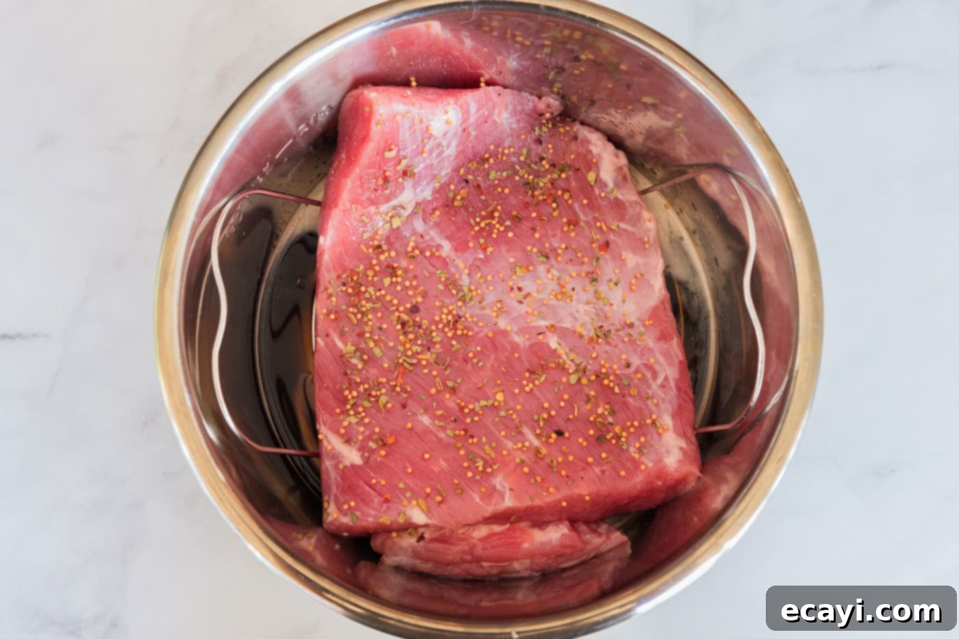 Tender Instant Pot Corned Beef 7 Corned beef brisket placed on a rack in an Instant Pot, topped with its seasoning packet.