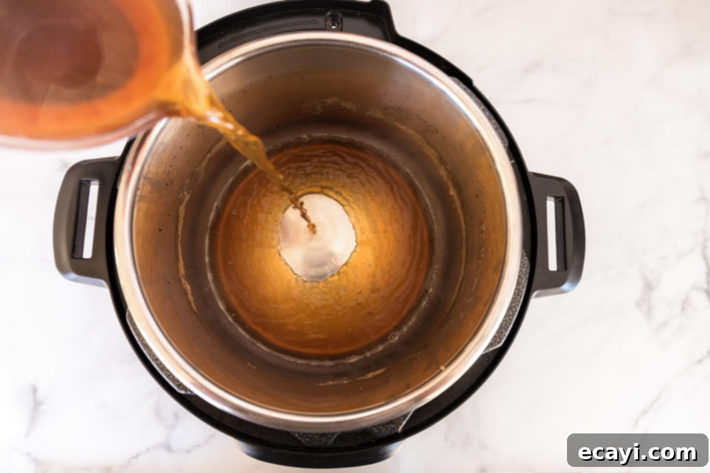 Tender Instant Pot Corned Beef 9 Flavorful liquid being poured back into the Instant Pot for cooking vegetables.
