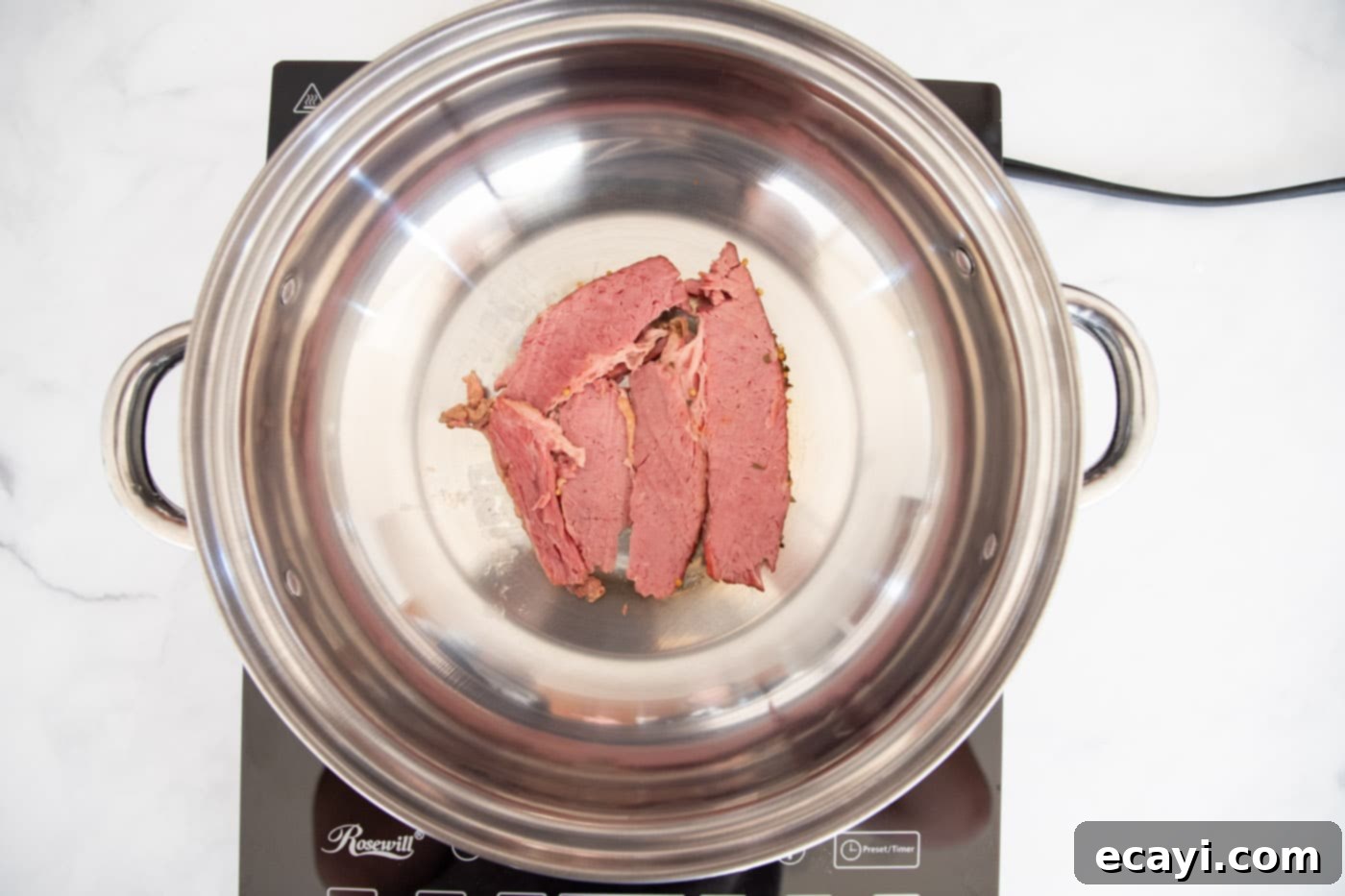 Classic Reuben Sandwich 6 Thinly sliced corned beef warming in a skillet, preparing for assembly into a delicious Reuben sandwich.