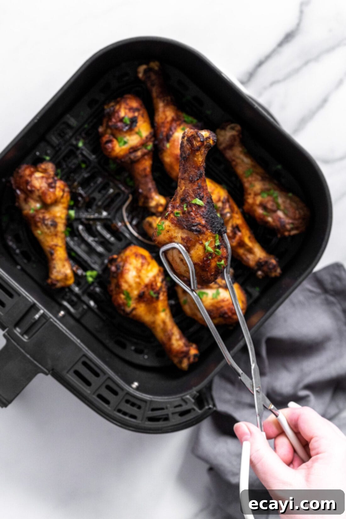 Golden Crispy Air Fryer Drumsticks 3 Chicken drumsticks cooking in an air fryer basket, achieving a golden crisp