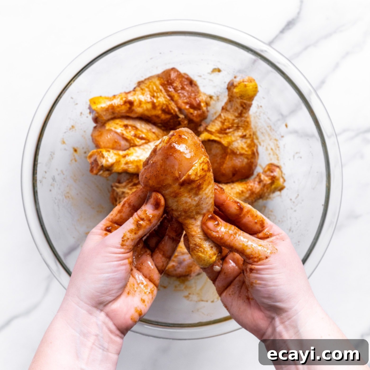 Golden Crispy Air Fryer Drumsticks 5 Chicken drumsticks in a bowl, generously coated with a vibrant spice blend and olive oil