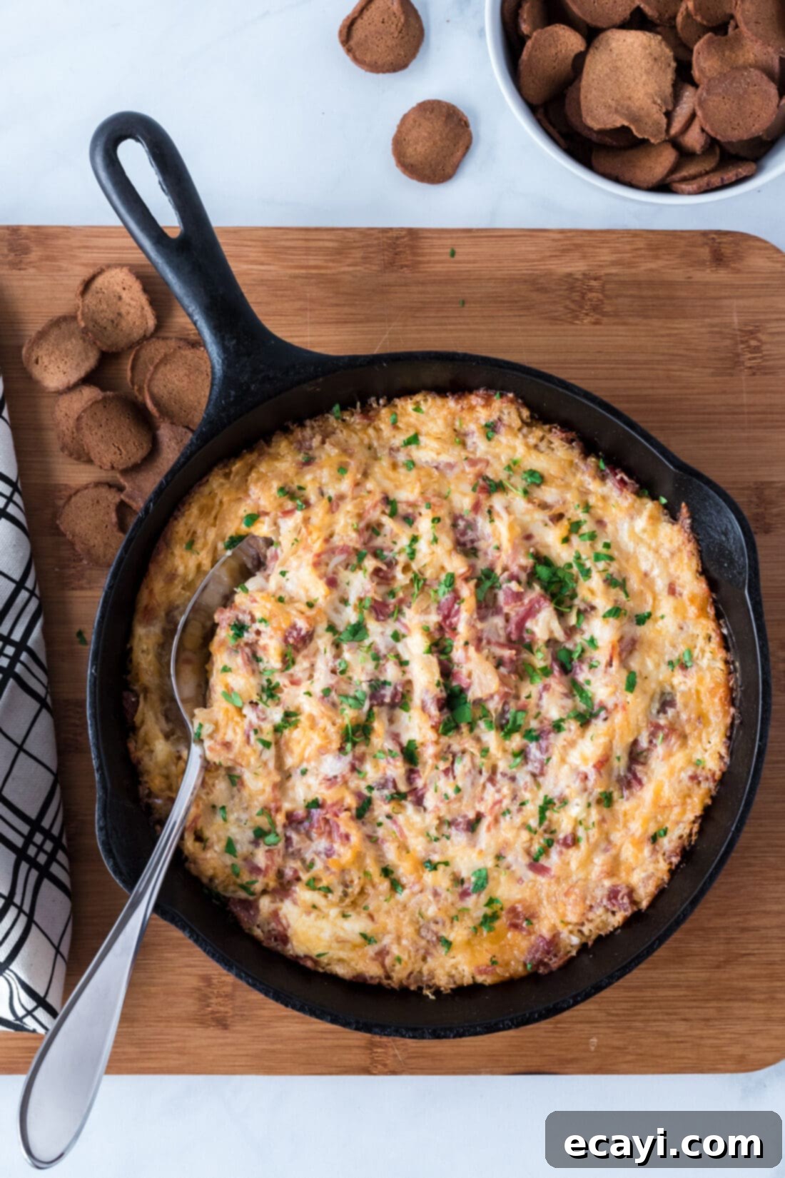 Decadent Reuben Dip 8 overhead shot of hot Reuben Dip in a cast iron skillet with dippers around it