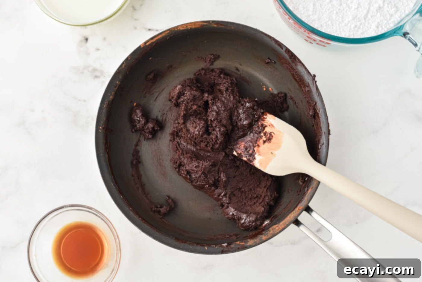 Velvet Chocolate Fudge Bliss 5 Thick chocolate and butter mixture in a saucepan, forming the base of the fudge frosting