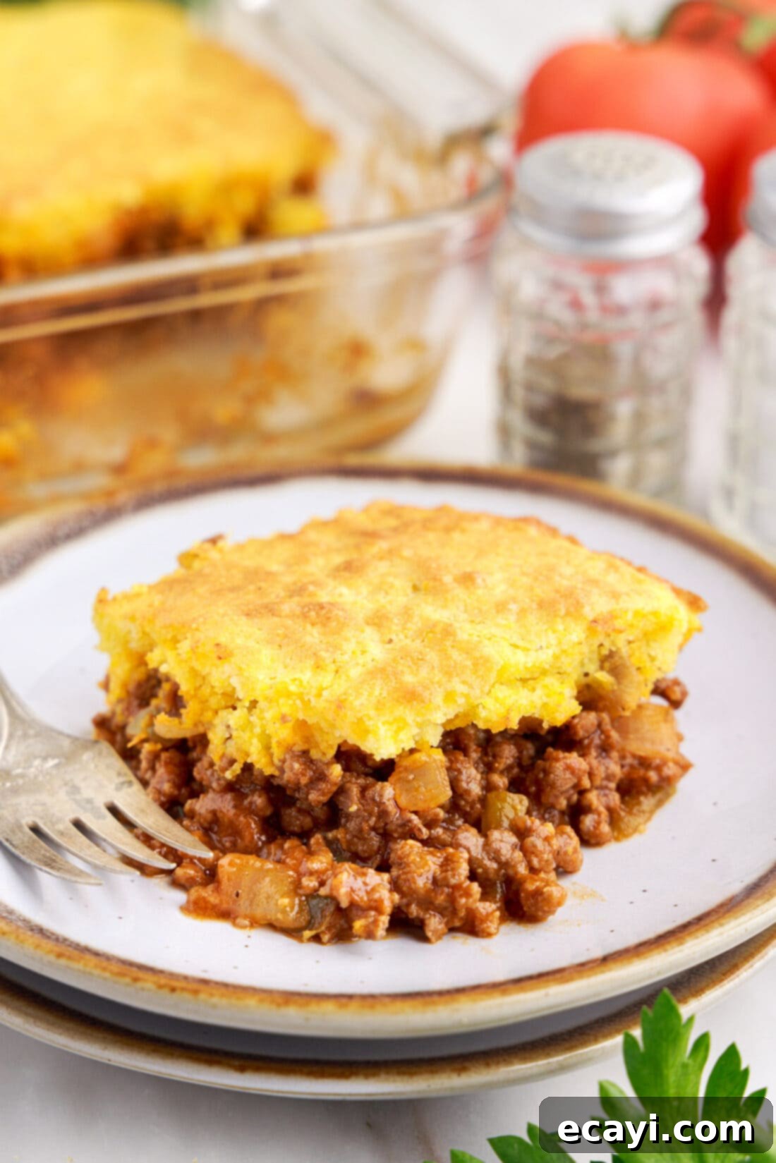 Hearty Sloppy Joe Cornbread Bake 3 plate of Sloppy Joe Cornbread Casserole, showing a perfect slice with visible layers of meat and cornbread