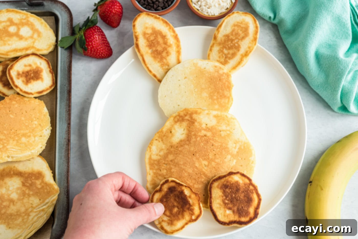 Fluffy Cottontail Stacks 10 bunny butt pancakes on a plate with fruit and whipped cream
