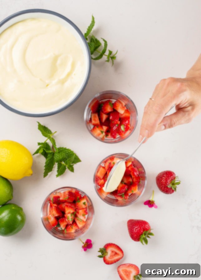 Refreshing Citrus Mousse with Macerated Strawberries 3 Close-up of a Citrus Mousse dessert layered with perfectly macerated strawberries, garnished with fresh mint