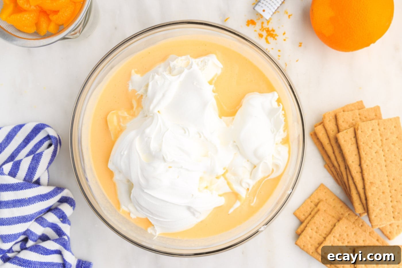 Orange Dreamsicle Delight 10 cool whip on top of pudding mix in a bowl