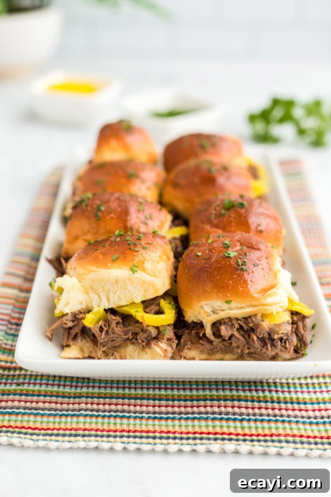 Slow Cooker Mississippi Pot Roast Sliders 2 Mississippi Pot Roast Sliders on a platter, showcasing their golden tops and delicious filling.