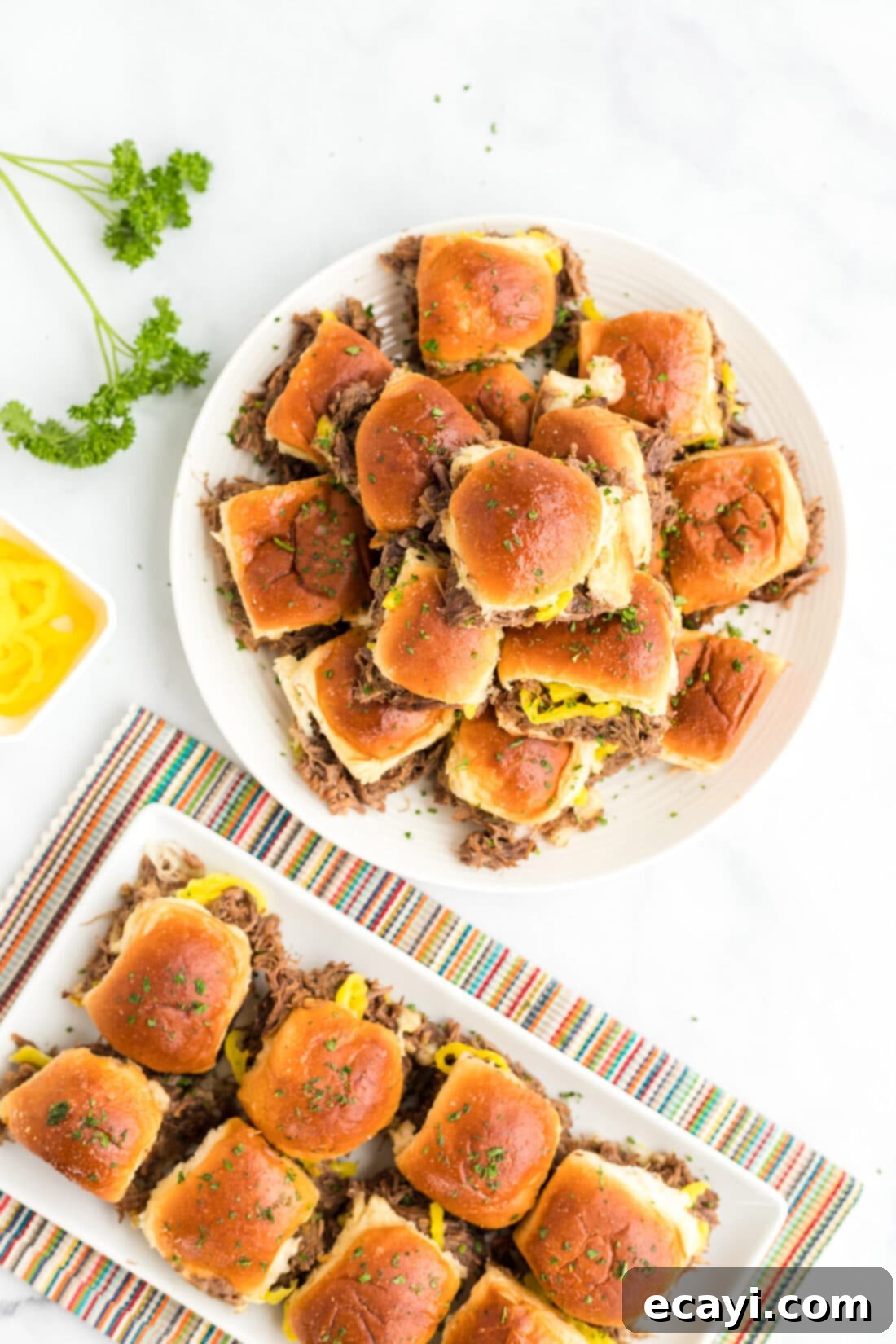 Slow Cooker Mississippi Pot Roast Sliders 11 A large platter generously filled with golden-brown Mississippi Pot Roast Sliders, ready to be served.