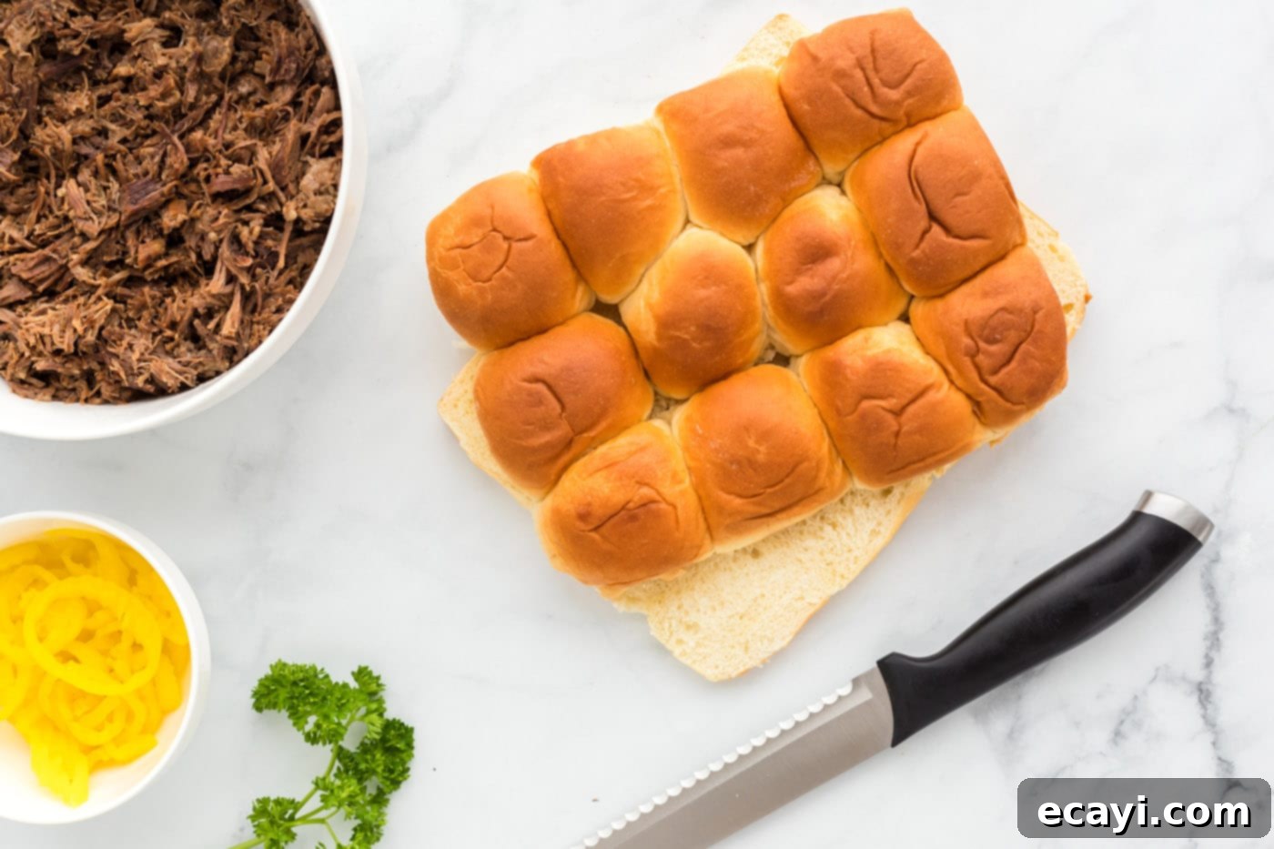 Slow Cooker Mississippi Pot Roast Sliders 5 Sliced Hawaiian rolls showing the top and bottom halves separated.