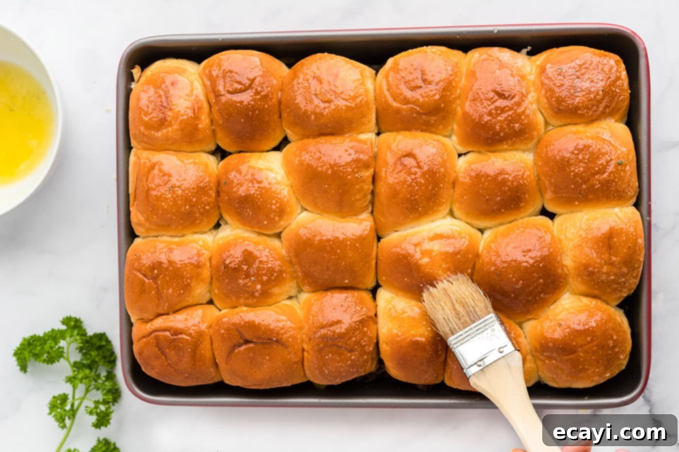 Slow Cooker Mississippi Pot Roast Sliders 10 Brushing garlic butter mixture onto the tops of the Mississippi Pot Roast Sliders.