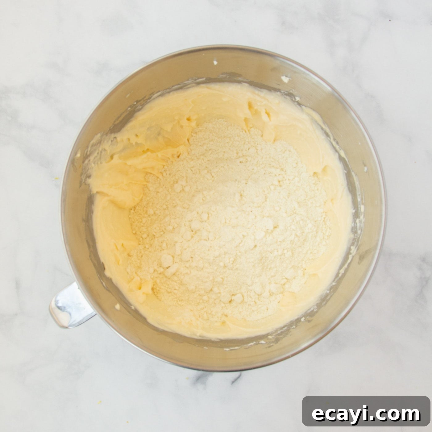 Bright Lemon Cake Mix Cookies 9 Dry lemon cake mix being added to the wet cookie dough ingredients