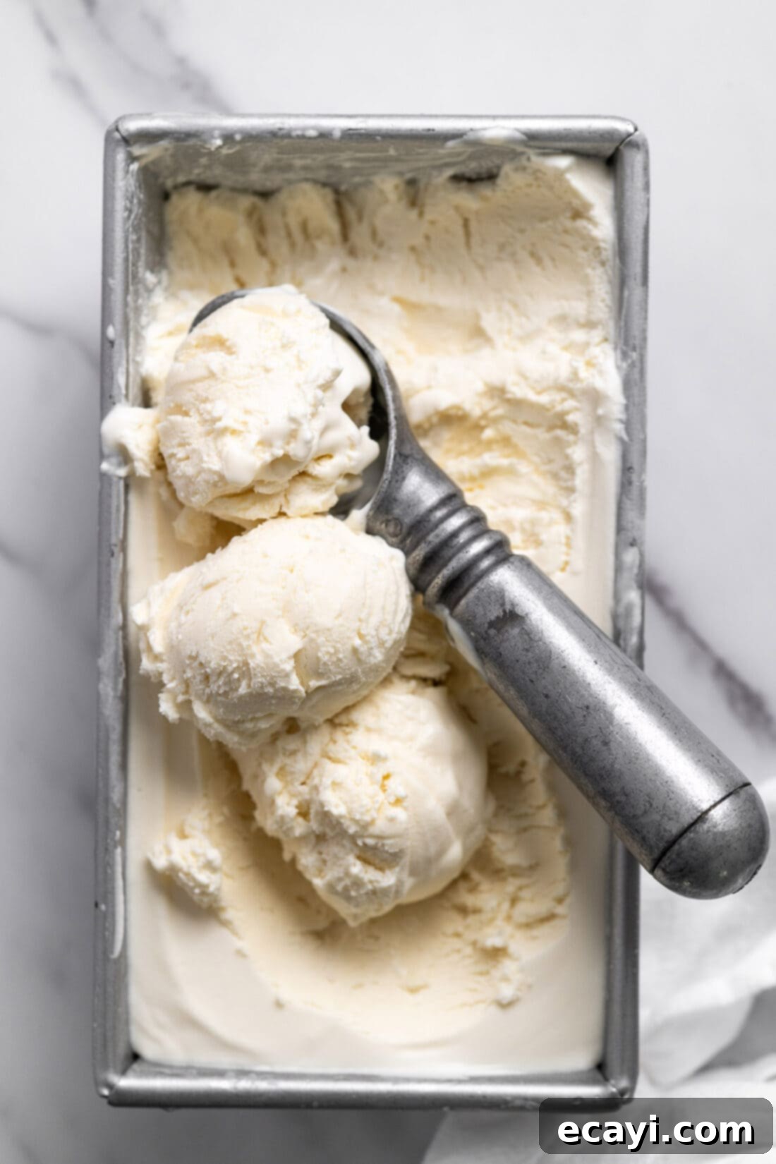 No-Fuss Creamy Ice Cream 13 Three scoops of no-churn vanilla ice cream in a chilled loaf pan