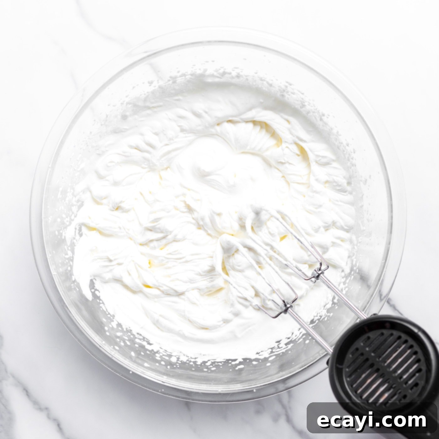No-Fuss Creamy Ice Cream 6 Using a hand mixer to beat heavy whipping cream to stiff peaks in a bowl