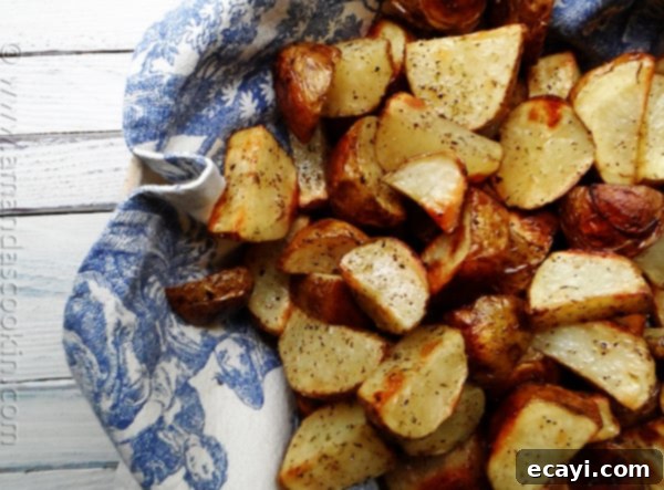 Side Dish: Roasted Potatoes  A close up photo of cut up roasted potatoes, perfectly seasoned and golden brown, to serve with the chicken.