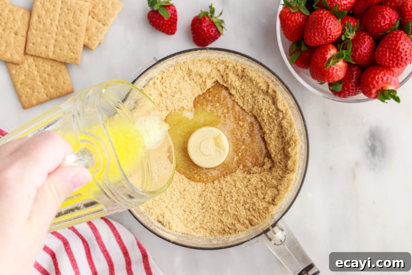 Strawberry Tiered Trifle 7 pouring melted butter over graham cracker crumbs