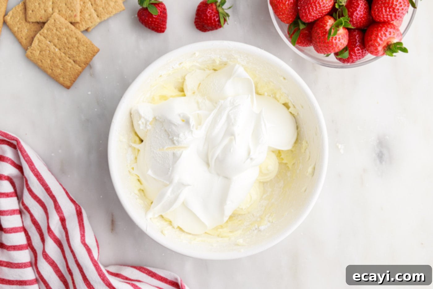 Strawberry Tiered Trifle 9 cool whip on top of cheesecake mixture in a bowl