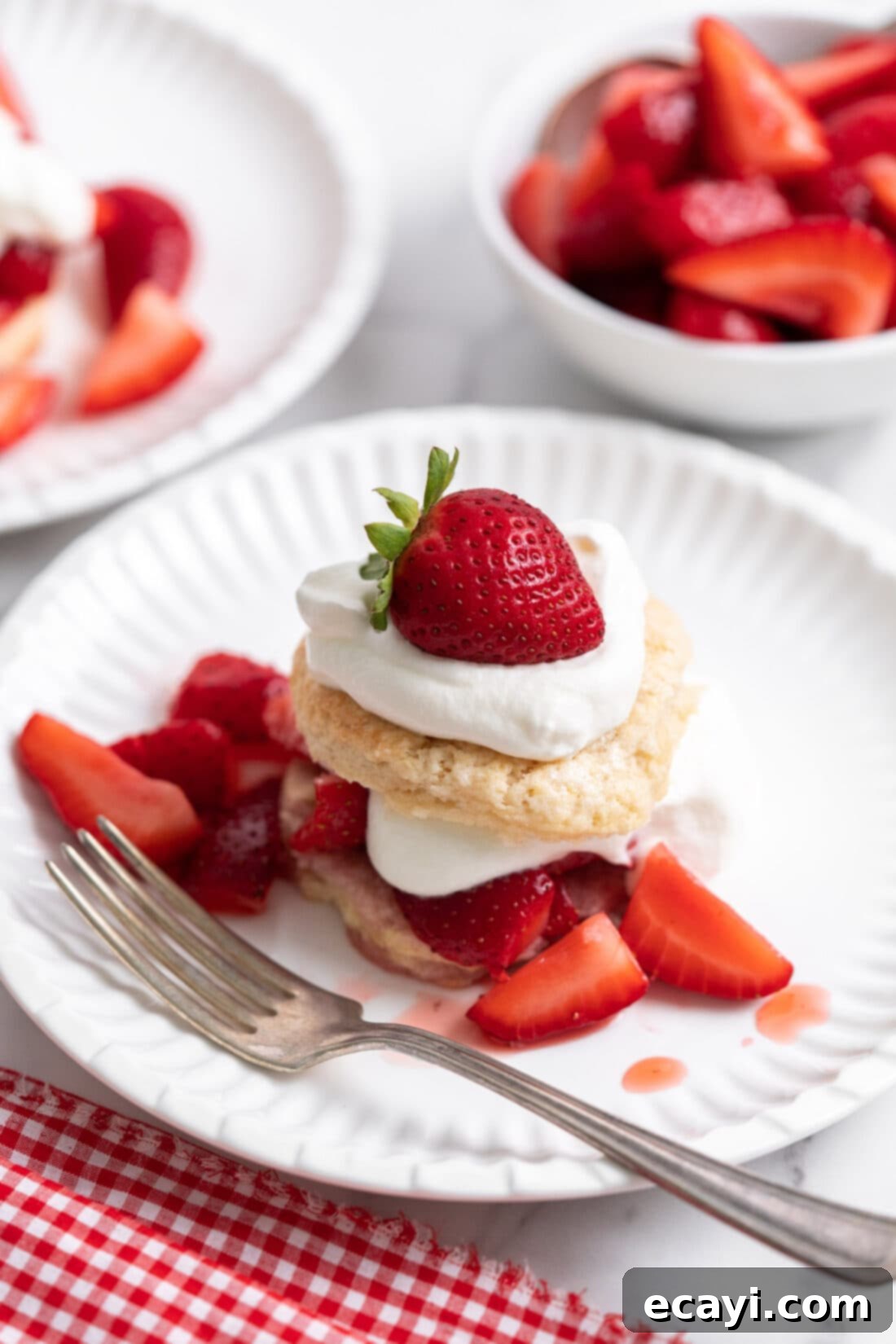 Garden Fresh Strawberry Shortcake 19 A perfectly assembled Strawberry Shortcake on a white plate with a fork, ready to be eaten