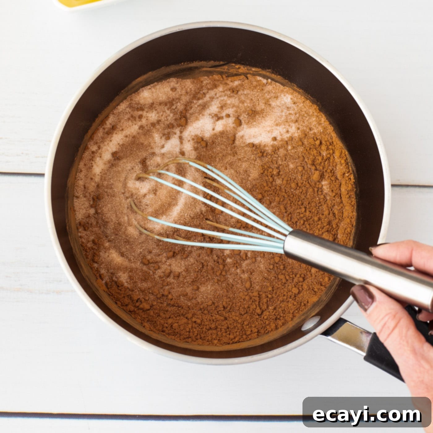 Quick Chocolate No-Bake Delights 6 Close-up of sugar and cocoa powder being whisked together in a saucepan
