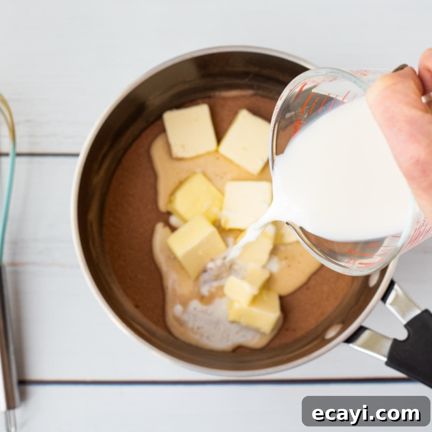 Quick Chocolate No-Bake Delights 7 Pouring milk into a saucepan containing butter, sugar, and cocoa powder