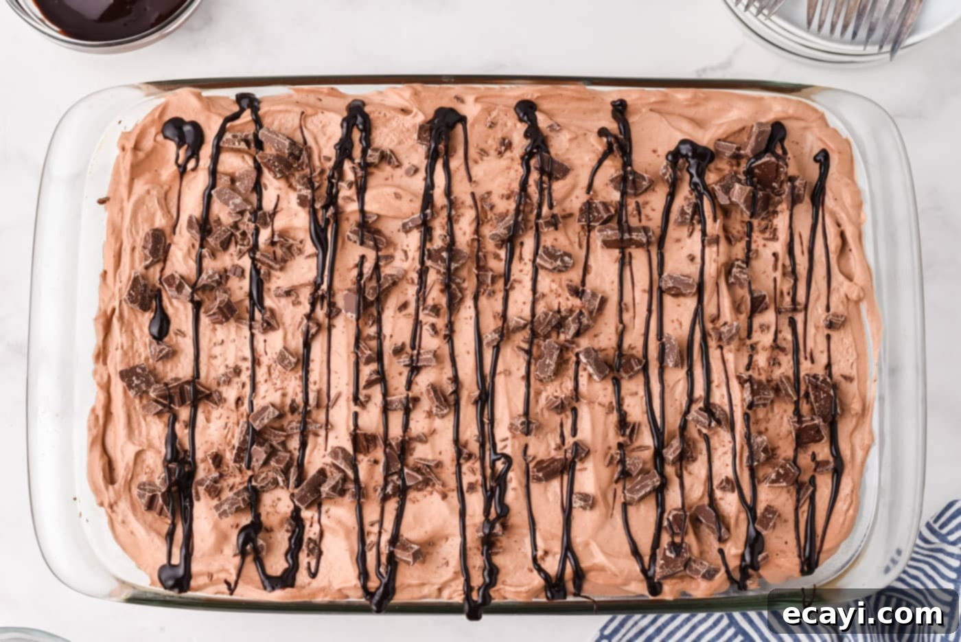 Decadent Chocolate Infusion Cake 11 Finished chocolate poke cake garnished with chopped chocolate and chocolate syrup drizzle