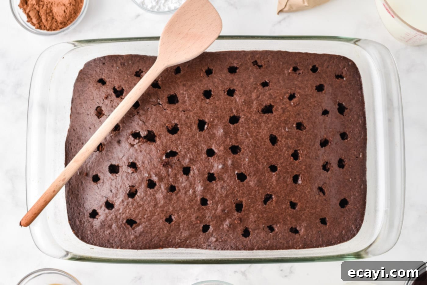 Decadent Chocolate Infusion Cake 6 Warm chocolate cake with evenly spaced holes poked with a wooden spoon