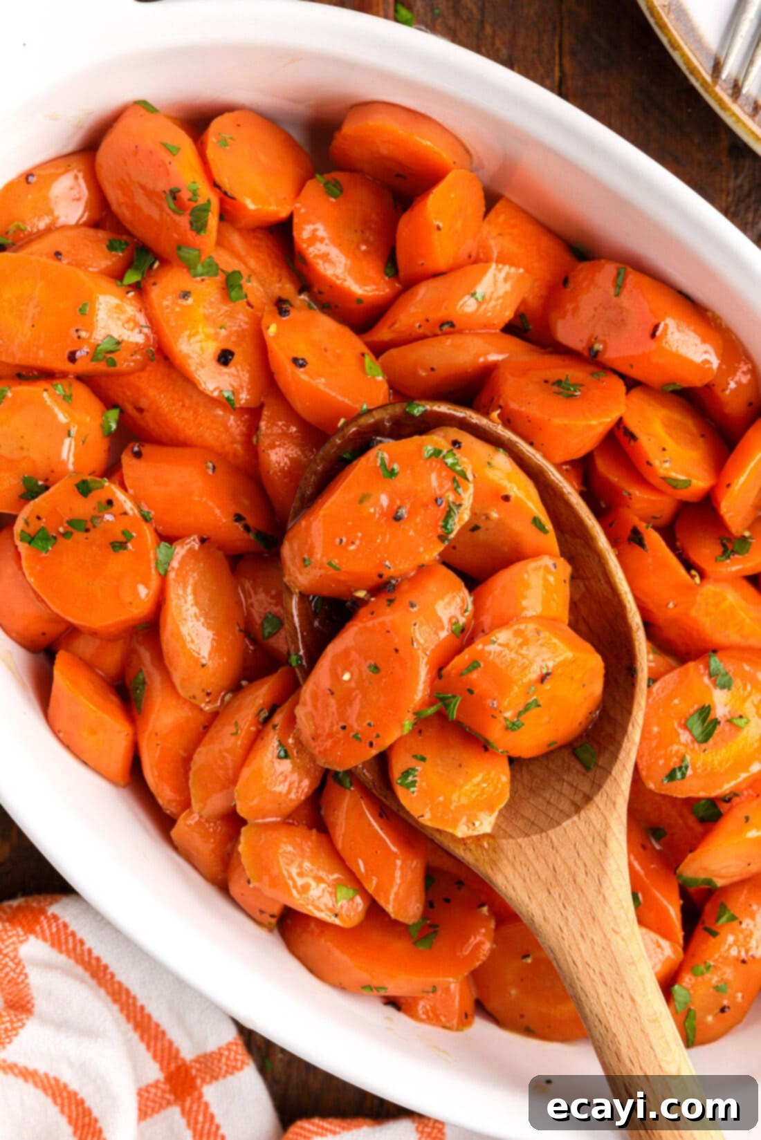 Sweet Glistening Carrots 2 wooden spoon lifting Glazed Carrots