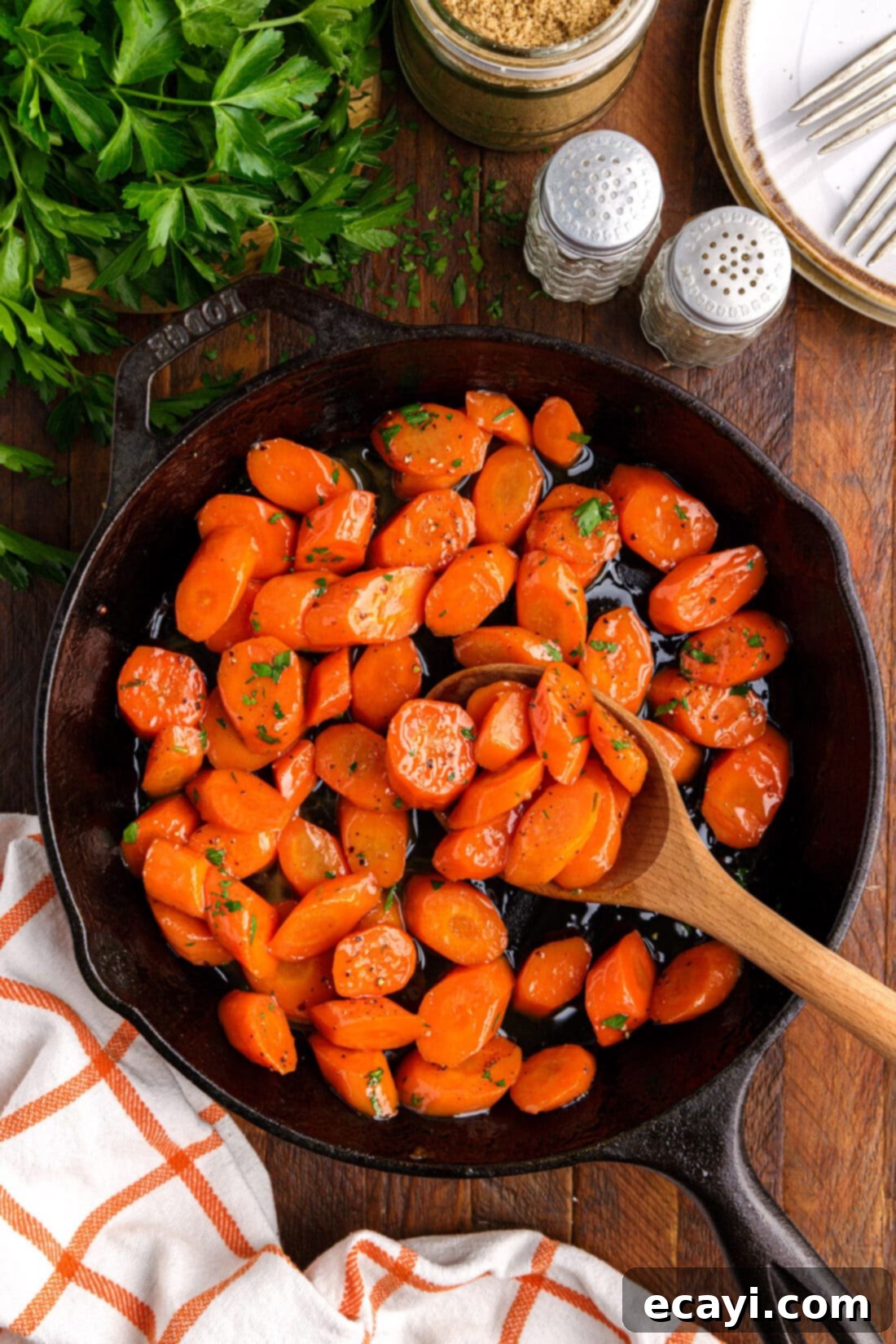 Sweet Glistening Carrots 3 wooden spoon in skillet of Glazed Carrots